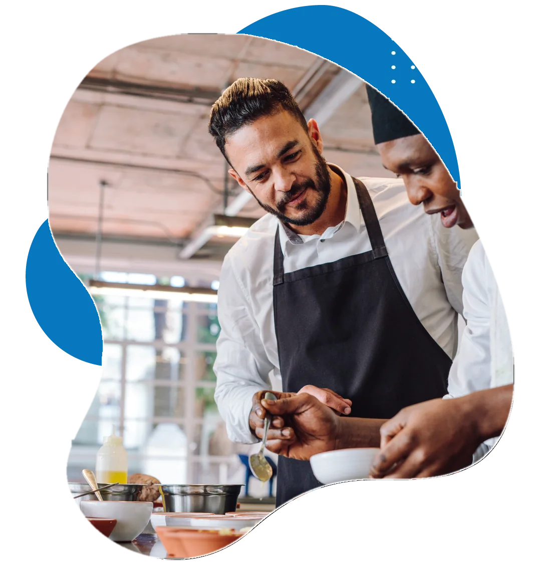 Chefs preparing dishes together in a restaurant kitchen