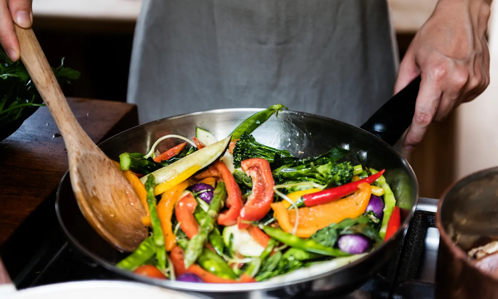 Fresh vegetables being stir-fried in a restaurant pan